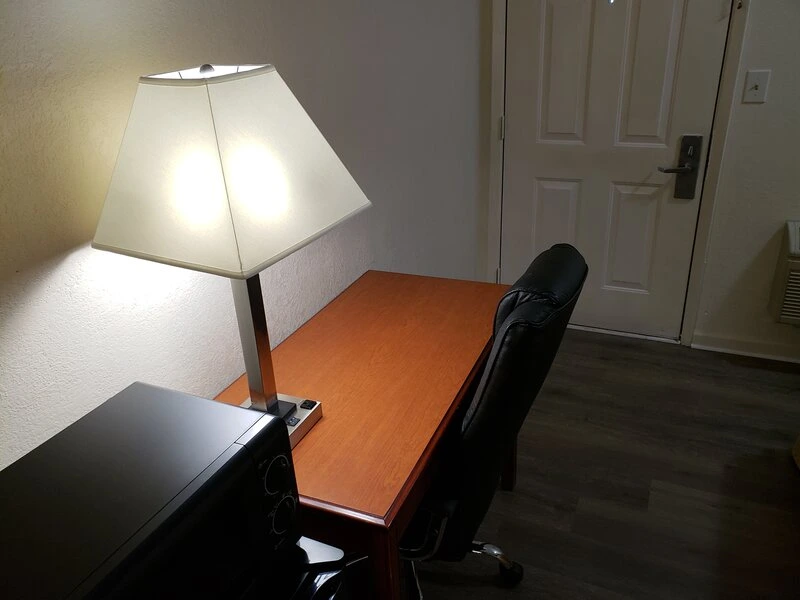 Work desk with lamp and office chair in guest room at Travel Inn of Buford