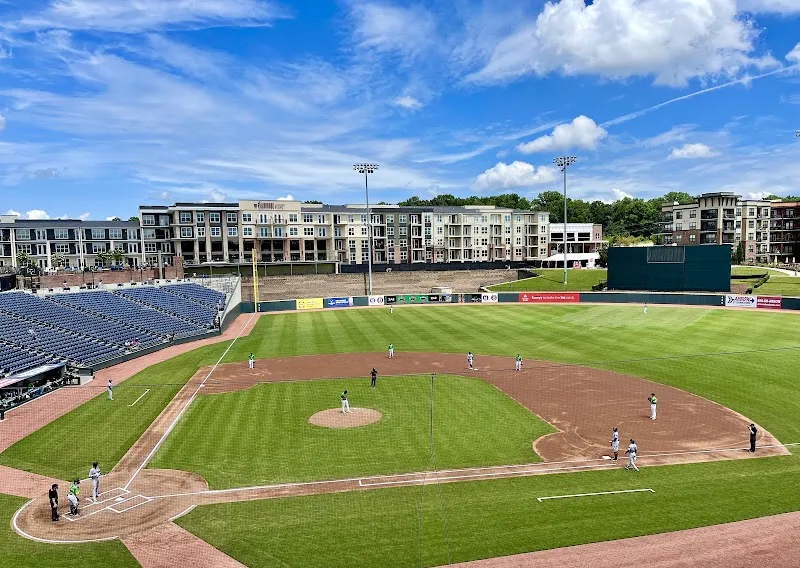 Baseball game in progress at Coolray Field with apartments beyond outfield