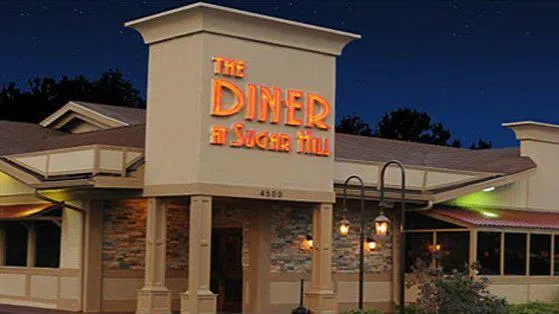 Exterior of The Diner at Sugar Hill restaurant at night with neon sign.